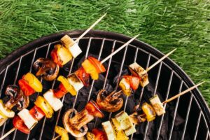 Diverse soorten rookhout bbq op een houten tafel met een barbecue op de achtergrond