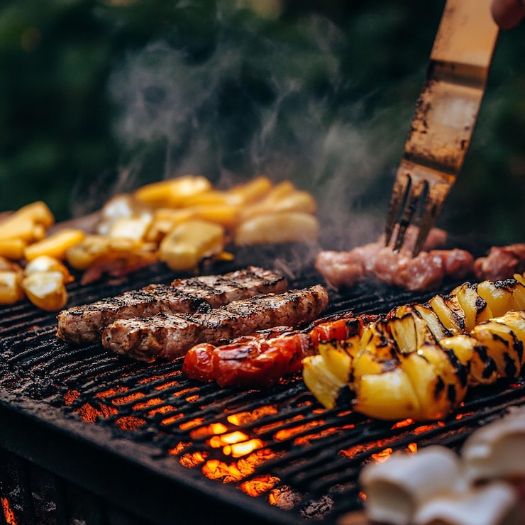 Close-up van een gas bbq temperatuur regelen met een thermometer en grillvlees erop